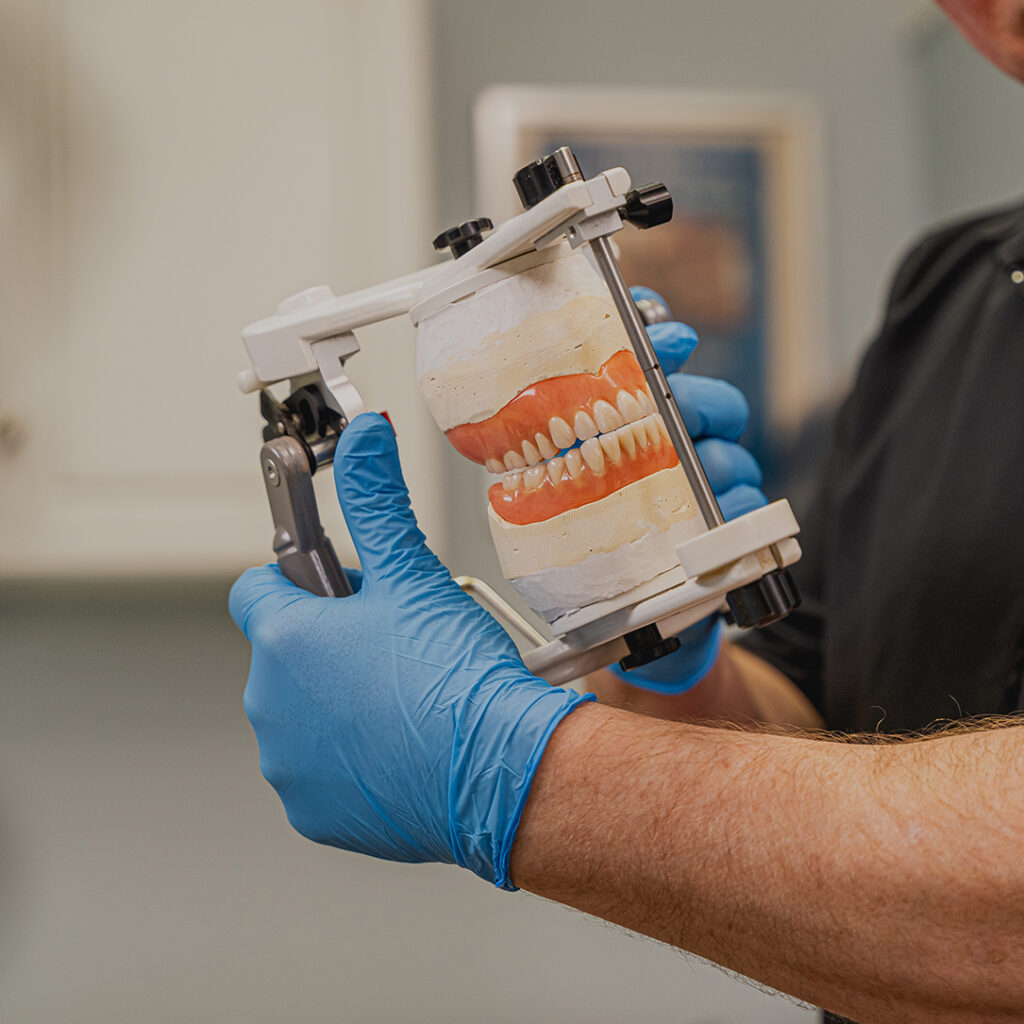 Michael Battell holding a denture model