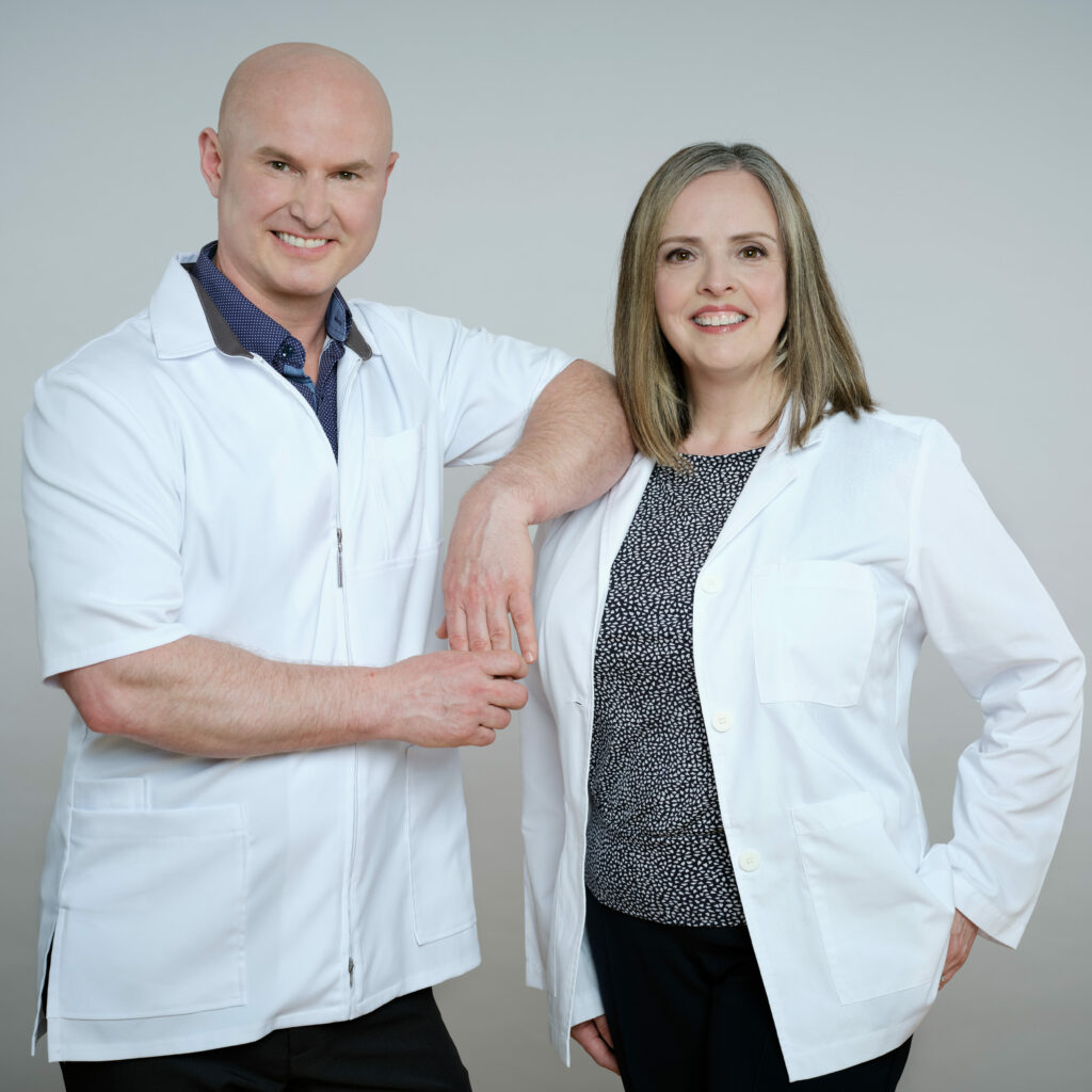 Michael Battell and Battell Denture Clinic Receptionist, Trish standing side by side, smiling in white lab coats.